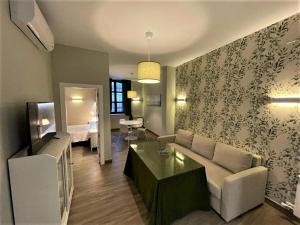 a living room with a couch and a table at Apartamentos Sol del Prior in Úbeda