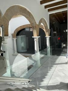 - un sol en verre dans un bâtiment avec des arches dans l'établissement Apartamentos Sol del Prior, à Úbeda