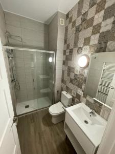 y baño con aseo, lavabo y ducha. en Apartamentos Sol del Prior en Úbeda