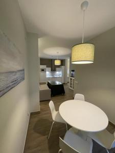 sala de estar con mesa blanca y sillas en Apartamentos Sol del Prior en Úbeda