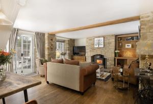 a living room with a couch and a fireplace at Old Stable Cottage in Kingham