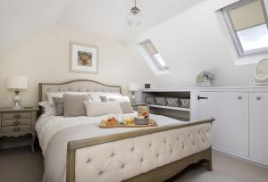 a bedroom with a bed with a tray of food on it at Old Stable Cottage in Kingham