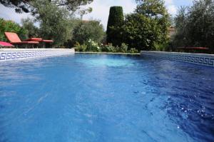 uma piscina com água azul num quintal em bastide St Joseph em Eyguières