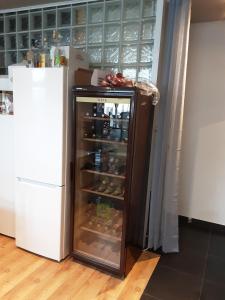 an open refrigerator in a kitchen next to a white refrigerator freezer at ’t Wielerpension in Steenhuize-Wijnhuize