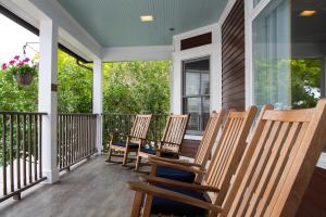 - une rangée de chaises à bascule sur une terrasse couverte dans l'établissement Lake View Hotel, à Île Mackinac