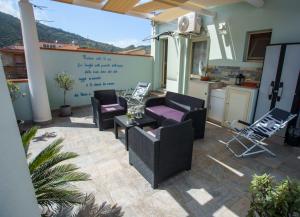 a patio with couches and a table and a kitchen at La casa del pescatore in Oliveri