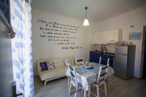 a living room with a table and a kitchen at La casa del pescatore in Oliveri