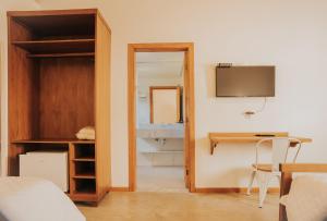 a bedroom with a bed and a desk and a mirror at Pousada Cheiro da Terra - Sem Café da Manha in Capitólio