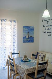 a dining room with a table and a sailboat on the wall at La casa del pescatore in Oliveri