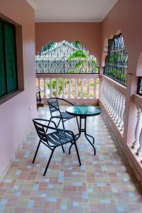 Pokój ze stołem i krzesłami oraz witrażami w obiekcie Dondoo's Paradise- Perfect Vacation Home w mieście Kilifi