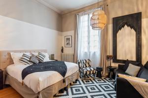 ein Schlafzimmer mit einem Bett und ein Wohnzimmer in der Unterkunft Sourire Boutique Hôtel Particulier in Paris