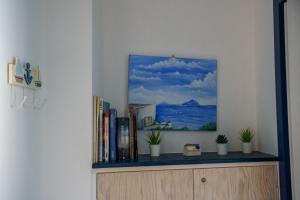 a shelf with books and a painting on a wall at La casa del pescatore in Oliveri