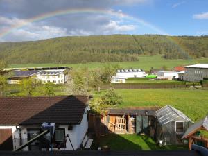 einen Regenbogen über einem Dorf mit Häusern und einem Feld in der Unterkunft Apartment da Elisa in Rietheim-Weilheim