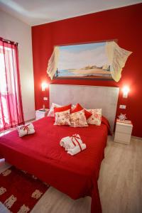 a red bedroom with a bed with towels on it at La casa del pescatore in Oliveri