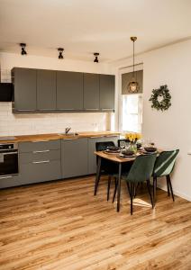 a kitchen with a table and chairs in a room at MOOD Apartamenti Kuldīgā in Kuldīga