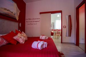 a bedroom with a red bed with two towels on it at La casa del pescatore in Oliveri