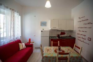 een woonkamer met een rode bank en een tafel bij La casa del pescatore in Oliveri