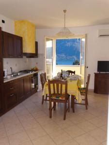 een keuken met een tafel met een geel tafelkleed bij Casavalery Appartamento monolocale con vista lago in Bellagio