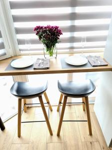 a table with two chairs and a vase of purple flowers at PremierAtlant in Dnipro