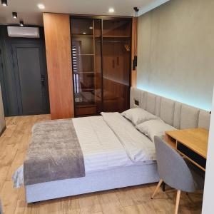 1 dormitorio con cama, mesa y escritorio en PremierAtlant, en Dnipro