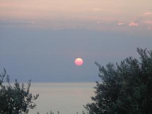a sun rising over the ocean at sunset at Sea Front in Milina
