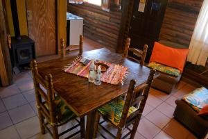 a wooden table in a room with a fireplace at Kpriccio Cabanas in Potrerillos
