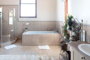 a bathroom with a tub and a sink at Castello Di Monte in Pretoria