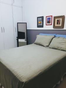 1 cama grande en un dormitorio con espejo en Cantinho familiar-Humaitá - somente mulheres - just women, en Río de Janeiro