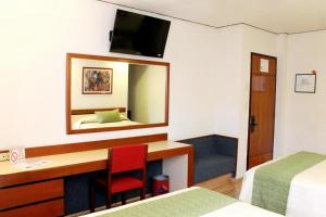 Cette chambre comprend un bureau et un miroir. dans l'établissement Hotel Manalba, à Mexico