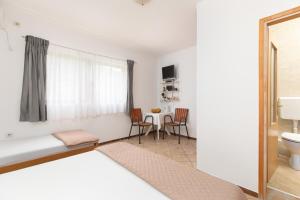 a bedroom with a bed and a table with chairs at Apartments Bojić in Tivat