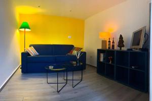 un soggiorno con divano blu e TV di Loft Orlando 52 a Catania