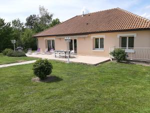 une maison avec une table et des chaises dans une cour dans l'établissement Les lits de la Py, à Sommepy-Tahure