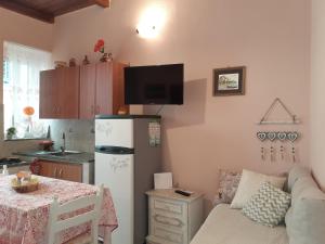 a kitchen with a couch and a refrigerator and a table at Astoria Tropea Centro storico in Tropea