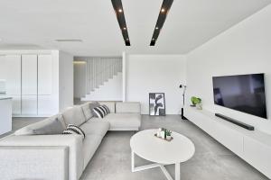 TV a/nebo společenská místnost v ubytování Villa Lodi - new modern villa few steps from beach with heated pool