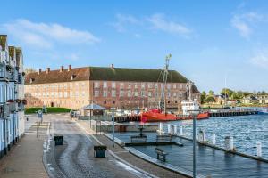 a marina with a building and a boat in the water at Grannys Harbour View - 1st floor in Sønderborg