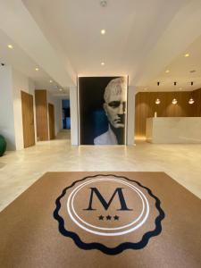ポルト・ヴェッキオにあるHôtel Le Mistralの床にmロゴが付いた広い客室です。
