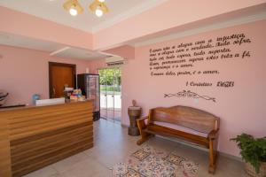 una sala de espera con un banco y escritura en la pared en Pousada Baía dos Açores, en Penha