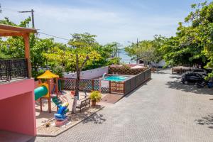 un patio trasero con piscina y parque infantil en Pousada Baía dos Açores, en Penha