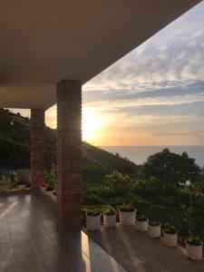 a view of the sunset from a patio with potted plants at Grand Seaview Apartments in Ksamil