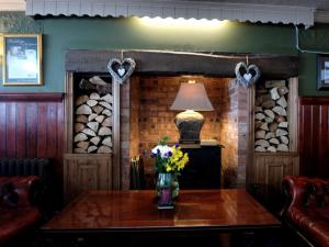 Cette chambre comprend une table avec des fleurs et une lampe. dans l'établissement The Gladstone, à Conwy