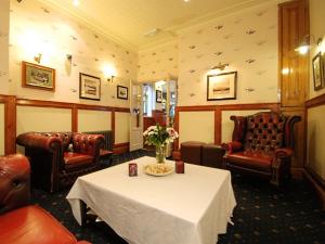 a waiting room with a table and leather chairs at The Gladstone in Conwy
