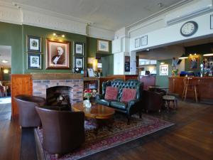 a living room with a fireplace and chairs and a table at The Gladstone in Conwy