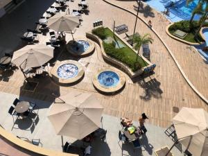 Alta Vista Thermas Resort في كالدس نوفاس: اطلالة علوية على مسبح به طاولات ومظلات