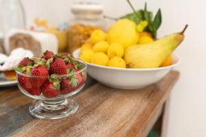 a bowl of fruit on a table with a bowl of strawberries at Ai Tre Mercati in Palermo