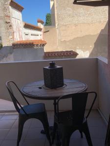 a table and chairs on a balcony with a box on it at Sète 2.0 in Sète