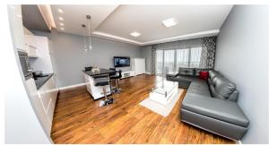 een woonkamer met een zwarte leren bank en een bureau bij Apartament 75,143 Porta Mare in Dziwnówek