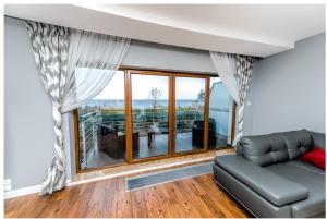een woonkamer met een bank en een groot raam bij Apartament 75,143 Porta Mare in Dziwnówek