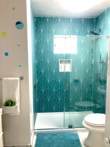 a bathroom with a blue tiled shower with a toilet at Viva San Diego in San Diego