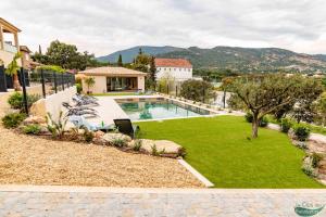 a backyard with a swimming pool and a lawn at Le Clos des Eucalyptus in Le Plan-de-la-Tour