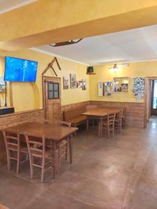 une salle à manger avec des tables, des chaises et une télévision dans l'établissement Locanda Da Tullio, à Capovalle